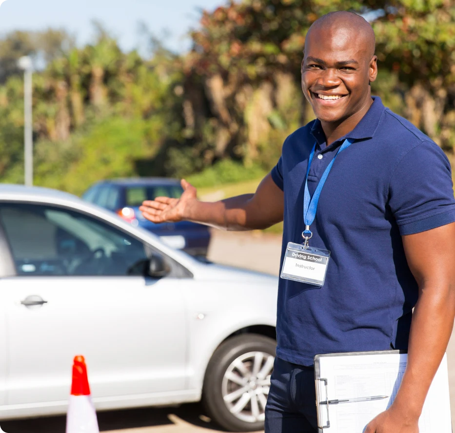 A man standing next to an orange cone.